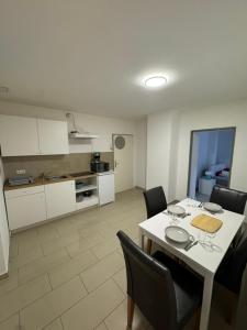 een eetkamer met een tafel en stoelen en een keuken bij Elegantes City-Apartment im MG-Zentrum in Mönchengladbach