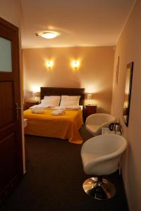 a hotel room with a bed and a chair at PLATINIUM House ex Royal House in Białogard