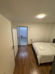 een slaapkamer met een bed en een houten vloer bij Elegantes City-Apartment im MG-Zentrum in Mönchengladbach +2 foto's