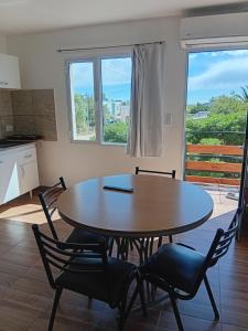 tavolo e sedie in una stanza con cucina di Brusa 1 a Las Grutas