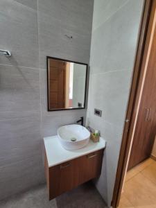 a bathroom with a white sink and a mirror at Prabhu Villla Upper Deck in Perumpāvūr +20 photos