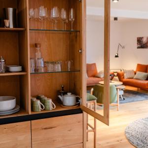 eine Küche mit Holzschränken und ein Wohnzimmer in der Unterkunft janzweitnah in Gerolstein