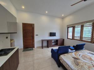a kitchen with a bed and a desk in a room at Prabhu Villla Upper Deck in Perumpāvūr