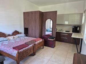 a bedroom with a large bed and a kitchen at Prabhu Villla Upper Deck in Perumpāvūr