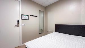 ein Schlafzimmer mit einem weißen Bett und einer Tür in der Unterkunft Nässjö Vandrarhem in Nässjö