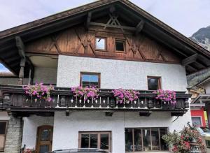 een huis met een balkon met bloemen erop bij Ferienhaus Lotta in Umhausen