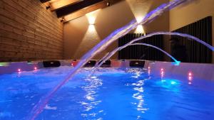 een zwembad met blauw water in een kamer met verlichting bij Alpinia in Majdal Shams