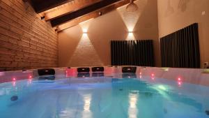 een grote hot tub in een kamer met stoelen bij Alpinia in Majdal Shams