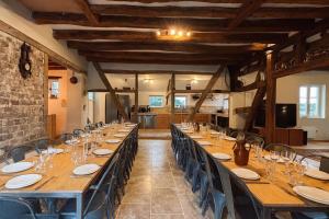 a long table in a large room with tables and chairs at Domaine Les Pigées in Saint-Privé