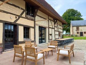 a group of chairs and tables in front of a building at Domaine Les Pigées in Saint-Privé
