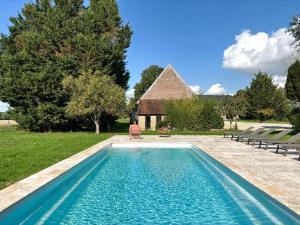 a swimming pool in front of a house at Domaine Les Pigées in Saint-Privé