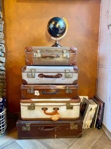una pila di valigie con un mappamondo sopra di Travel Wood - Sauna et Voyages a Waulsort