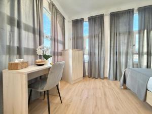a bedroom with a desk and a bed and windows at Maison Plancina in Rome