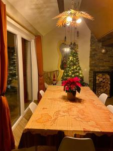 una sala da pranzo con tavolo e albero di Natale di Travel Wood - Sauna et Voyages a Waulsort Altre 19 foto