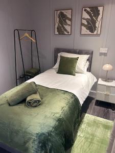 een slaapkamer met een bed met een groene deken erop bij Churchill Apartment- 4 Beds- Free Parking- Near NEC BHX & HS2 in Coleshill