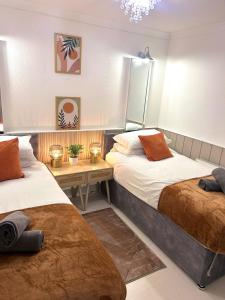 een slaapkamer met twee bedden en een spiegel bij Churchill Apartment- 4 Beds- Free Parking- Near NEC BHX & HS2 in Coleshill +17 foto's