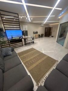 een woonkamer met een bank en een grote tv bij شاليهات ايفا in Taif