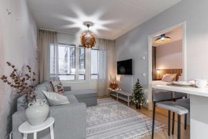 a living room with a couch and a table at Scandi Forest Flat Across from the Train Station in Rovaniemi
