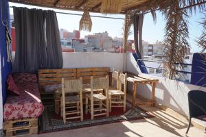 einen Balkon mit einem Tisch und Stühlen auf einem Schiff in der Unterkunft Waves House Tamraght - Surf & Chill Hostel in Tamraght Ouzdar