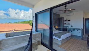 a bedroom with a bed and a balcony with a view at Casa del Mar Holbox in Holbox Island