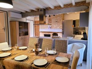 a dining room with a table and a kitchen at La Colline Truffière in Sourzac
