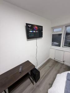 ein Zimmer mit einem Flachbildfernseher an der Wand in der Unterkunft Modern Rooms in North London in Edmonton