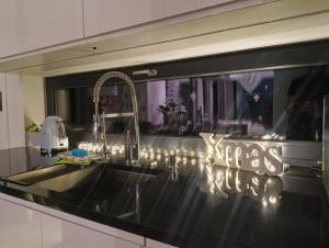 un bancone della cucina con lavandino e specchio di Willa Vivaldi a Grzybowo