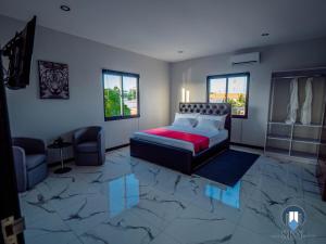 een slaapkamer met een bed, een bank en ramen bij Luxury Sky Group Penthouse With Free Gym & 2 Pools in Paramaribo +26 foto's