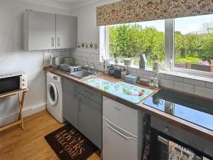 een keuken met een wastafel en een vaatwasser bij The Nest - Uk46879 in Woodbury