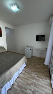 een slaapkamer met een bed en een flatscreen-tv bij Refúgio na Lagoa in Florianópolis +5 foto's