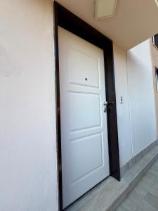 eine weiße Tür an der Seite eines Gebäudes in der Unterkunft GV Apartments in Garzano