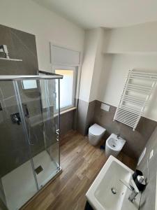 ein Badezimmer mit Dusche, Toilette und Waschbecken in der Unterkunft GV Apartments in Garzano + 10 Fotos