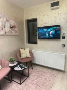 een woonkamer met een flatscreen-tv aan de muur bij ELLA LUX APARTMAN Čačak in Čačak