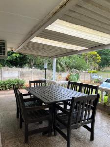 un tavolo in legno con sedie sotto un ombrellone da patio di Crème de la crème a Durban