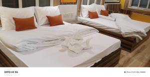 zwei Betten in einem Zimmer mit Handtüchern darauf in der Unterkunft Hotel Dinantika International in Bolpur