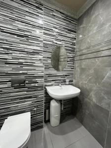 un bagno con lavandino, WC e specchio di Crème de la crème a Durban