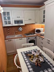 een keuken met een tafel met een spin erop bij Bernina House in Chiesa in Valmalenco