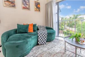 een woonkamer met een groene bank en een balkon bij Retro Pop FREE Parking Fast Wifi Pool Large Workspace in Sandton