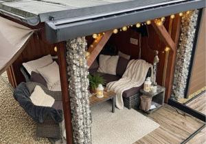 ein Pavillon mit Sofa und Stühlen auf einer Veranda in der Unterkunft Wellness -Residenz Ehrhardt Urlaub mit Pool und Garten Ferienwohnung in Halberstadt in Halberstadt