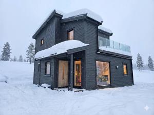 een zwart huis met sneeuw erop bij House with great location in Trysil