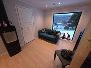 een woonkamer met een bank en een groot raam bij House with great location in Trysil