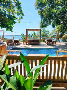a patio with benches and a pool and the ocean at El Xalli Hotel in El Zonte