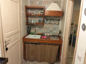 een kleine keuken met een spoelbak en een fornuis bij sciammaca house camera 2 in Agnone Bagni +5 foto's