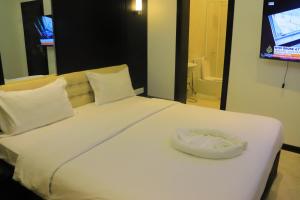 Al Jardāʼفندق غلاديلاس的一张白色的大床,上面有白色枕头