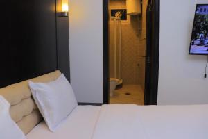 Al Jardāʼفندق غلاديلاس的一间带白色床的卧室和一间浴室 更多3张照片