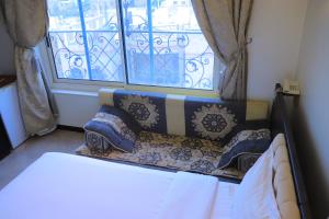 Al Jardāʼفندق غلاديلاس的配有枕头的窗户的客房内的一张床位