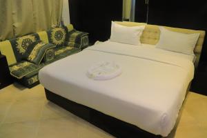 Al Jardāʼفندق غلاديلاس的一张白色大床,上面有帽子