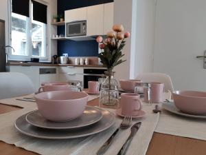 een eettafel met kommen en borden en een vaas met bloemen bij O paradis in Beaune +5 foto's