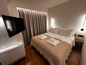 een slaapkamer met een bed met twee handdoeken erop bij Aje Villas 1959 in Ligiades +57 foto's