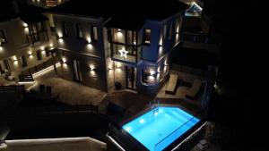 een uitzicht op een gebouw met 's nachts een zwembad bij Aje Villas 1959 in Ligiades